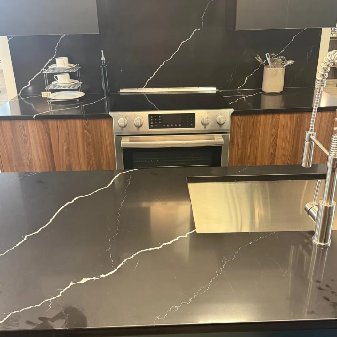 Black kitchen countertops with white veining and sink