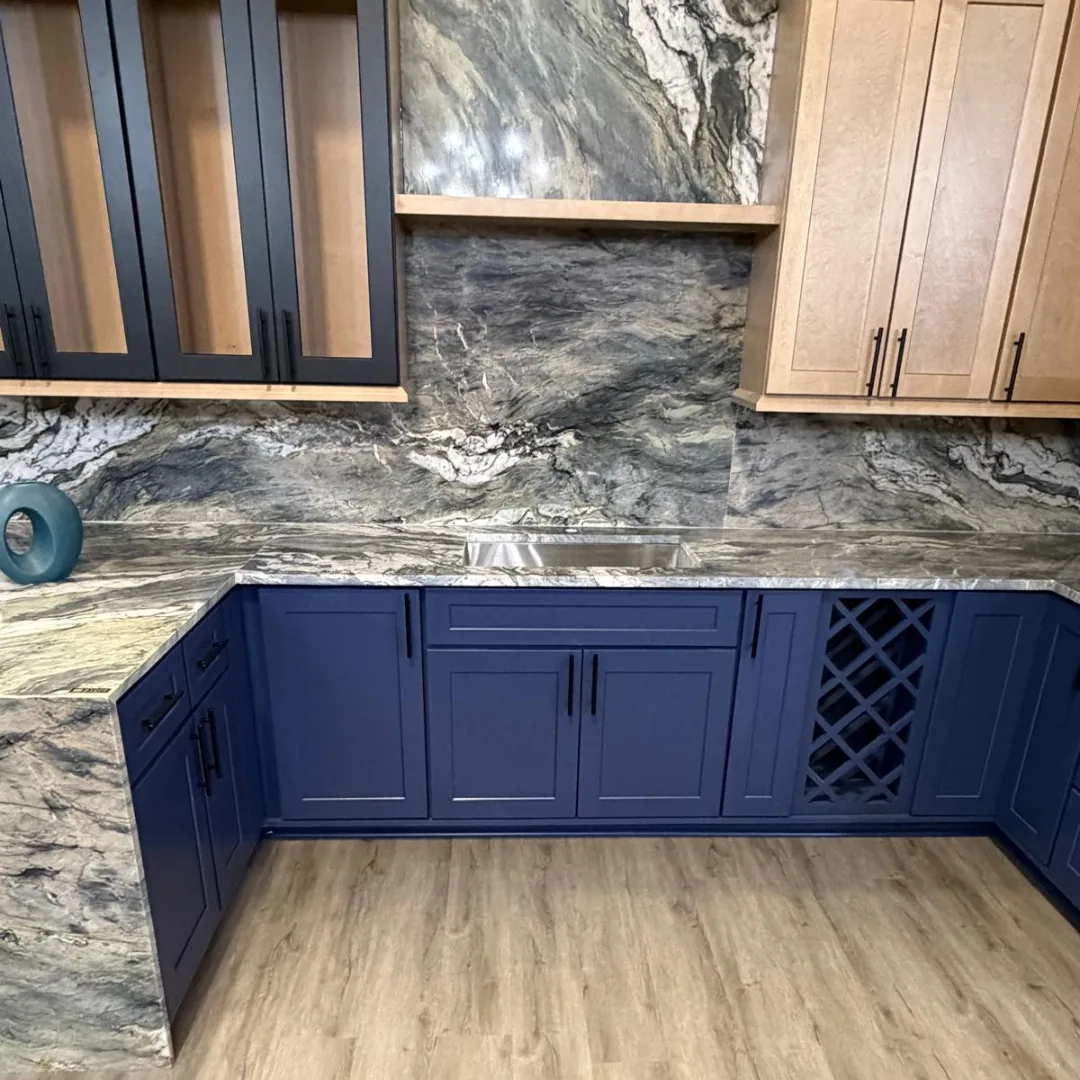 Navy blue cabinets with granite countertops and backsplash.