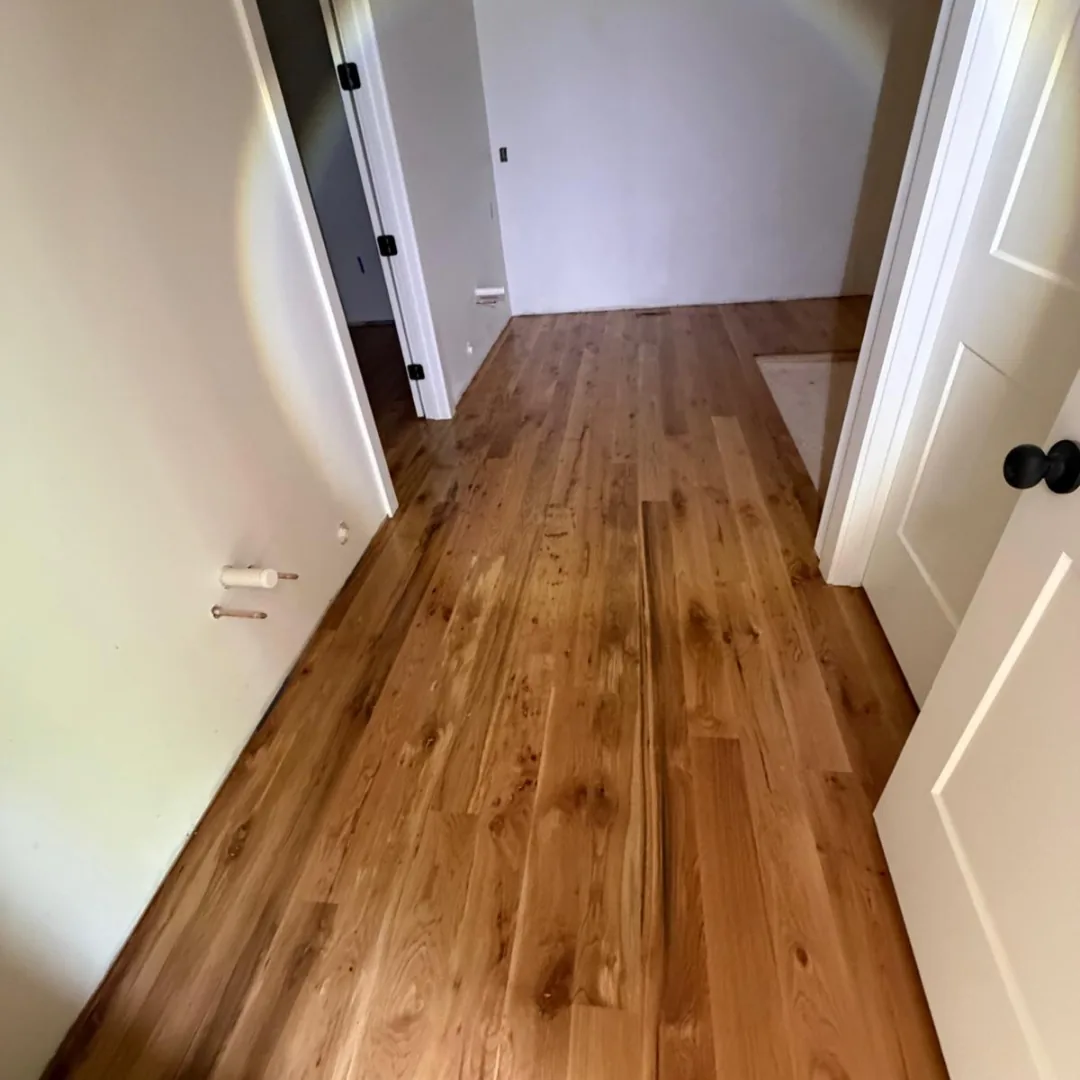 Newly installed hardwood flooring in hallway.