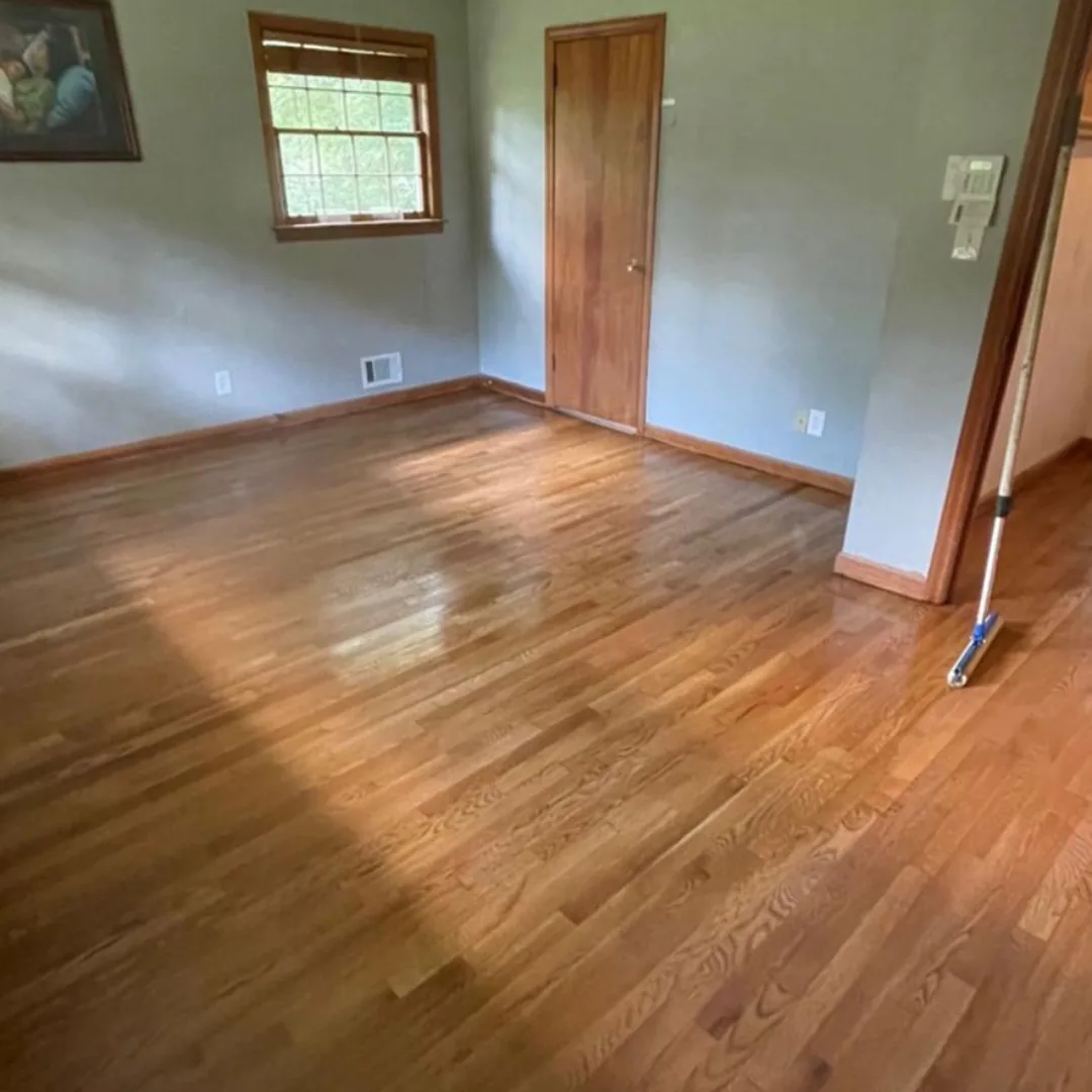 Newly refinished hardwood floors in empty room.