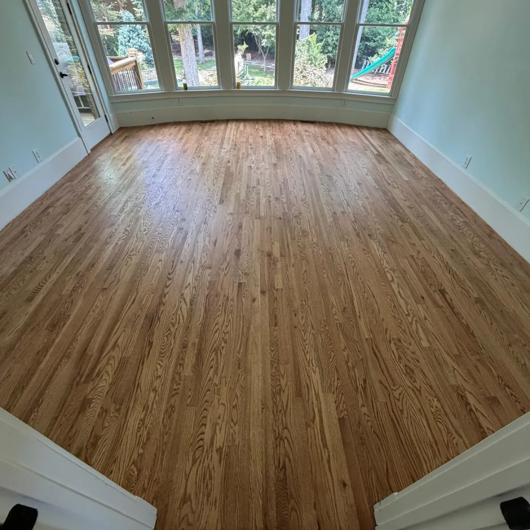 Newly installed hardwood floors in an empty room.
