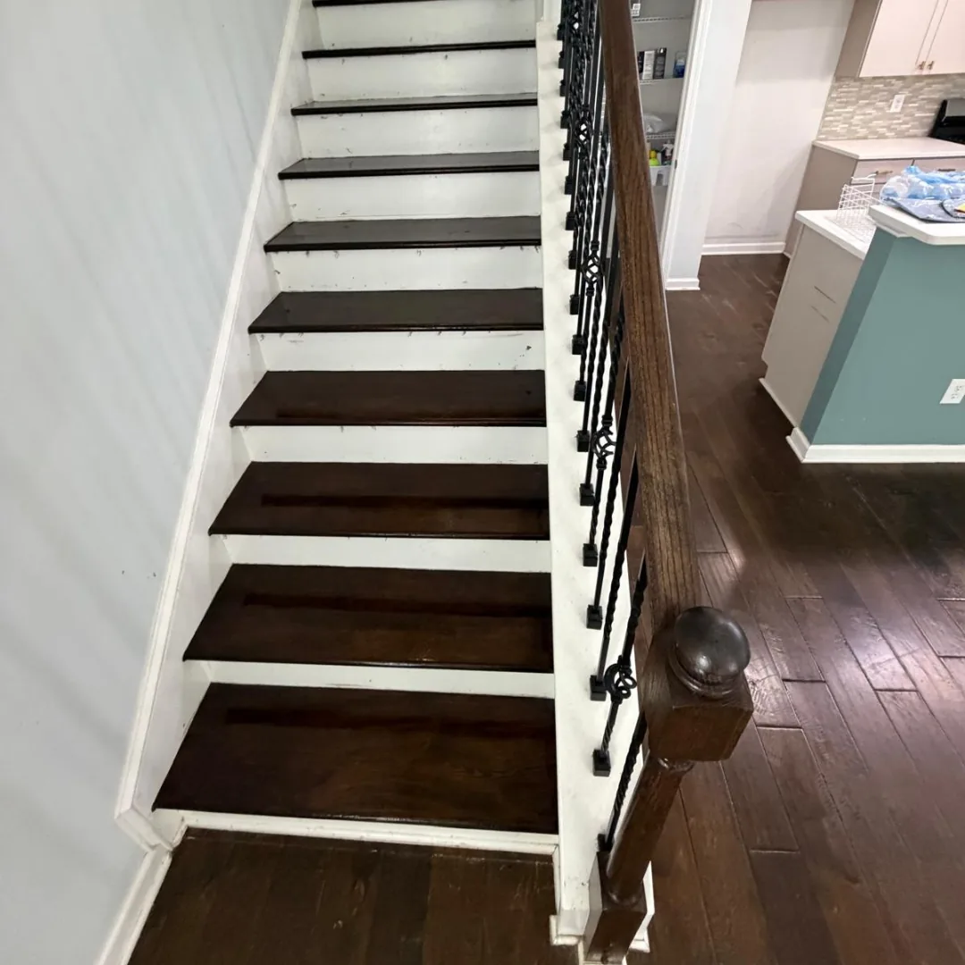 Refinished dark wood stairs with white risers and railing