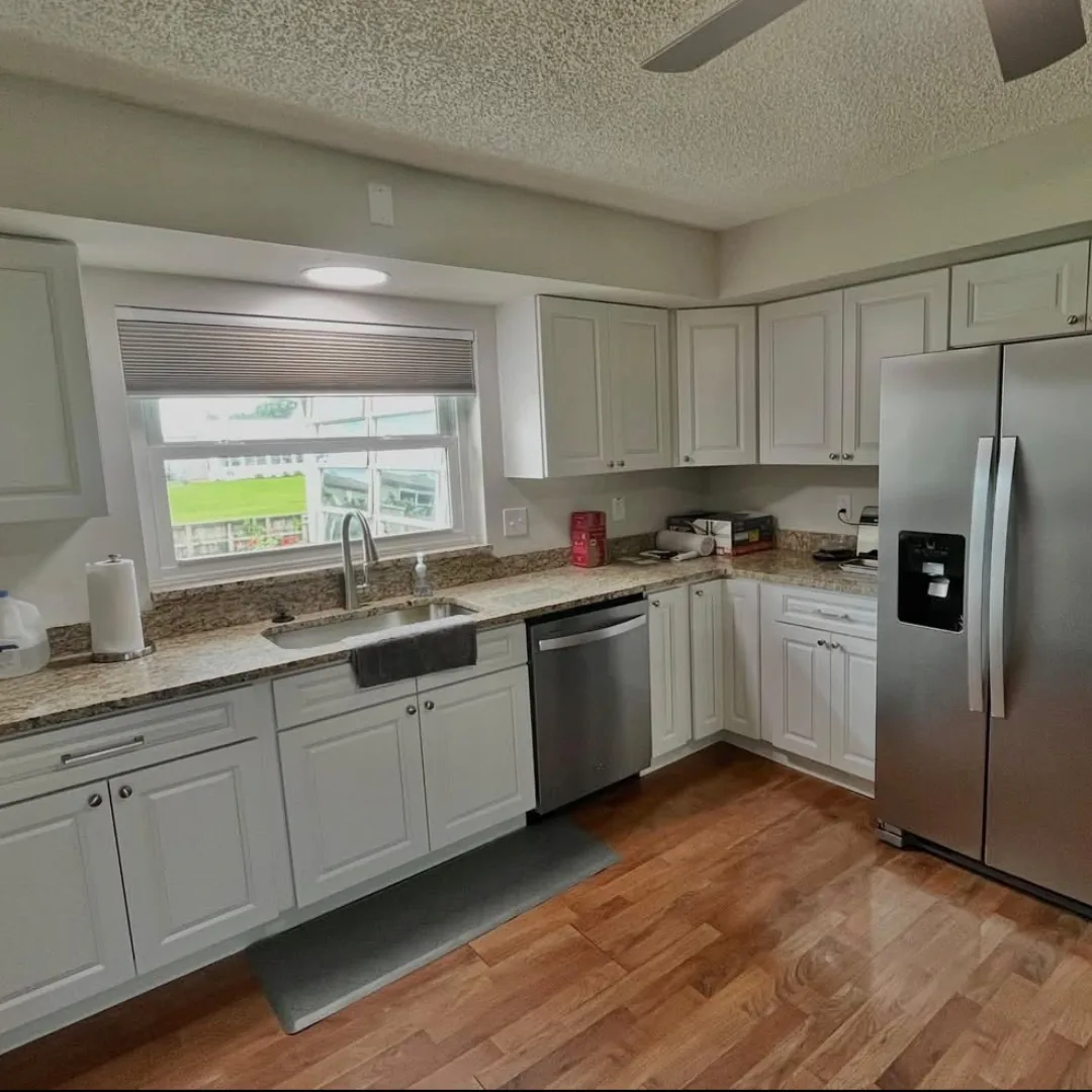 Gray shaker kitchen cabinets with granite countertops and hardwood flooring
