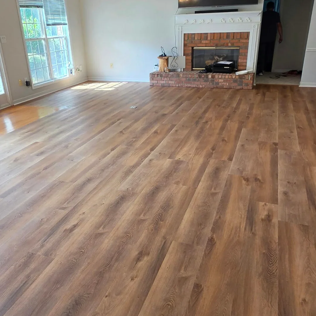 Luxury vinyl plank flooring in a living room with a brick fireplace